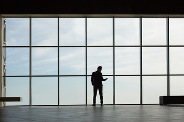 Obraz na płótnie Canvas Stylish business man in the background of a large window 