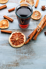 Tasty mulled wine and spices, on blue wooden background, close-up