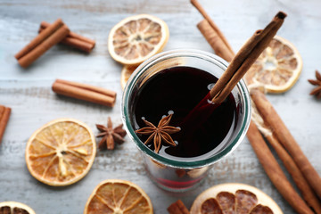 Tasty mulled wine and spices, on blue wooden background, close-up