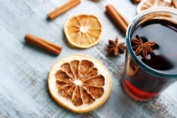 Tasty mulled wine and spices, on blue wooden background, close-up