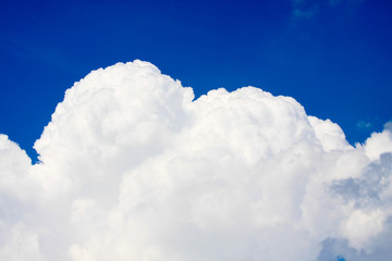 Naklejka na ściany i meble White fluffy cloud in the blue sky