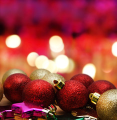 Christmas baubles on wooden table over golden bokeh background