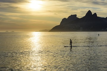 Stand up paddle at Arpoador beach in Ipanema during sunset