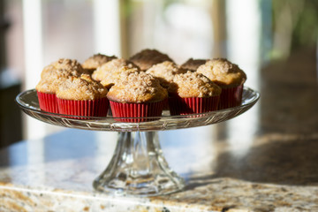 Banana Muffins in red paper cup on cake stand on kitchen counter