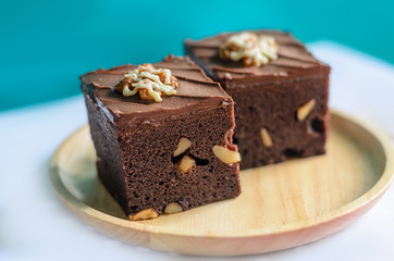 Chocolate Almond Brownies on wooden plate with green background