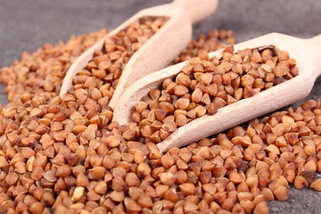 Buckwheat groats with spoon on cement structure