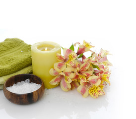 Branch yellow orchid and salt in bowl ,towel ,candle on white