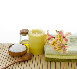 Fototapeta na wymiar Orchid on towel and spoon,salt in bowl ,towel ,oil, on bamboo mat