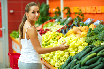 Young woman shopping in a supermarket in the department of fruit