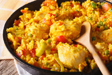 Rice with chicken and vegetables macro in a frying pan. horizontal
