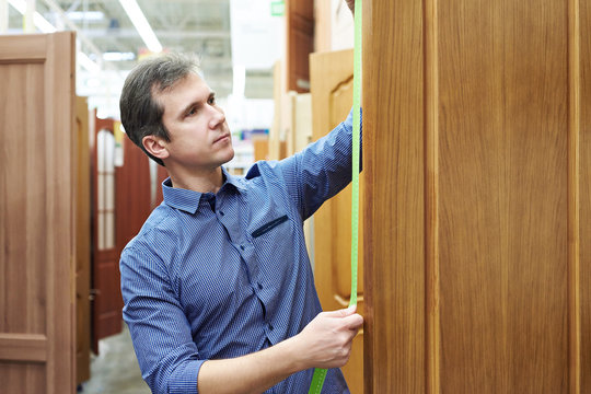 Man Customer Measures Door To Store Of Construction And Housekee