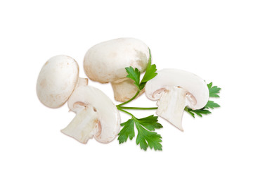 Several champignon mushroom and a leaf of parsley
