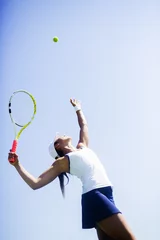 Zelfklevend Fotobehang Beautiful female tennis player serving © NDABCREATIVITY