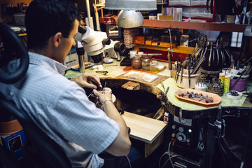 Jeweler working with optical device