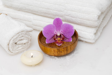 spa sitting with towel and candle ,orchid in bowl, candle