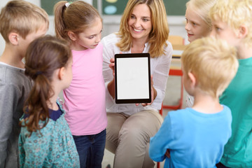 kinder in der grundschule schauen auf tablet-pc