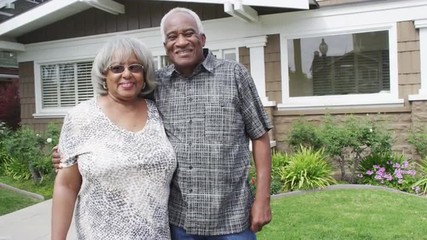 Happy senior black couple smiling in front of new home - Powered by Adobe