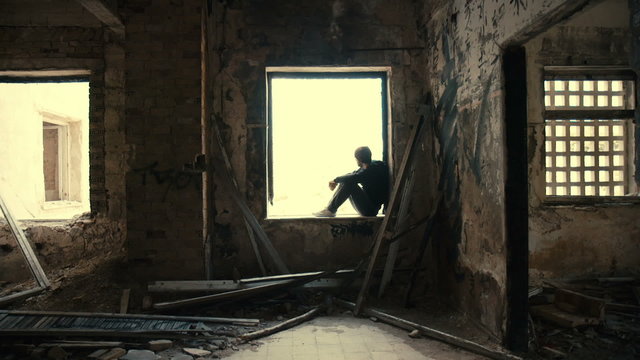 Troubled young man in wrecked abandoned building 