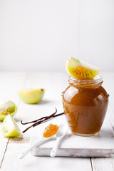 Green tomatoes jam with vanilla pods in a glass jar 
