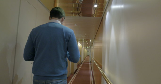 Adult Man Walking Along A Corridor Of Ocean Cruise Ship