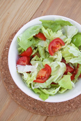 lattuga e pomodoro. ciotola di insalata su tavolo di legno