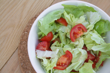 lattuga e pomodoro. ciotola di insalata su tavolo di legno
