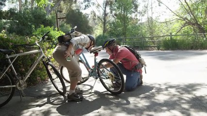 Senior couple checking bikes before going on trail - Powered by Adobe