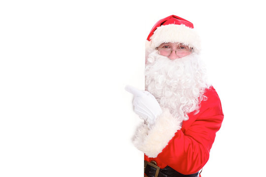 Kind Santa Claus pointing in white blank sign, isolated on white background