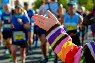 Marathon running race, support runners on road, child's hand giving highfive, sport concept
