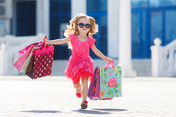 Little girl with shopping bags goes to the store - 96072748
