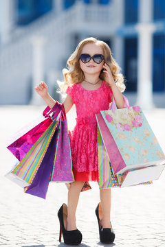 Little girl with shopping bags goes to the store
