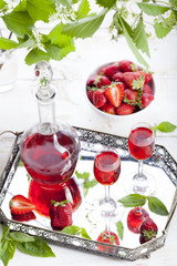 Strawberry and basil homemade liquor on a white background 