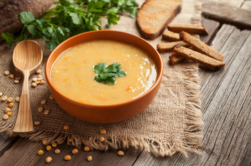 Pea soup healthy vegetarian organic food recipe with croutons and greens on rustic wooden table background. Homemade traditional meal