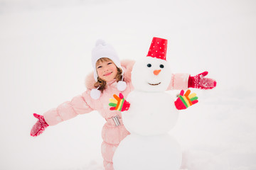 Child and snowman in winter