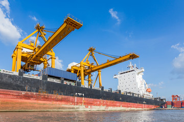 Fototapeta na wymiar Container cargo freight ship with working crane loading bridge in shipyard