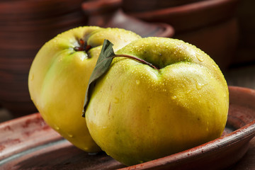Ripe yellow quince on a clay plate in a rustic style, selective