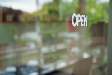 Wording "open" sticker on clear glass.