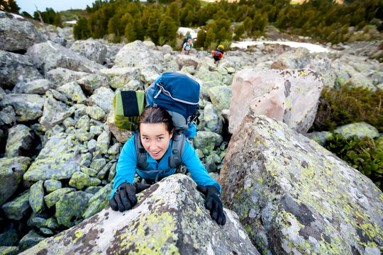 Young woman is climbing at stone whike trekking in highlands of