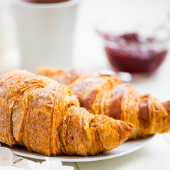 Fresh Croissants with Icing, Cup of Tea and Strawberry Jam