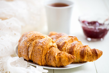 Fresh Croissants with Icing, Cup of Tea and Strawberry Jam