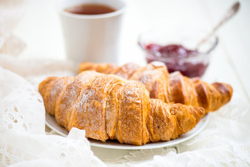 Fresh Croissants with Icing, Cup of Tea and Strawberry Jam