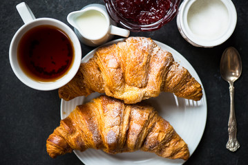Croissants with Icing, Cup of Tea, Milk, Sugar and Strawberry Ja