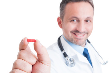 Doctor or medic holding and showing one red pill