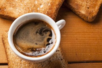 Coffee cup of  espresso with toast on wooden table