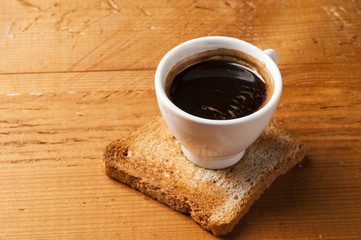 Coffee cup of  espresso with toast on wooden table