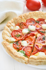 Tomatoes pie with cheese and green herbs