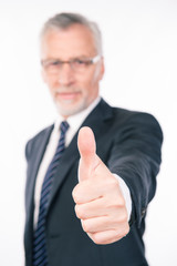 Confident businessman showing thumb up