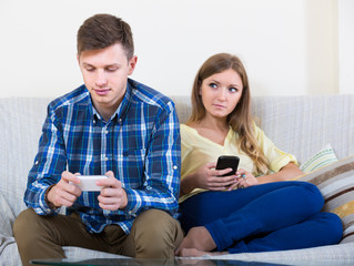 couple addicted to social networking with cell phones