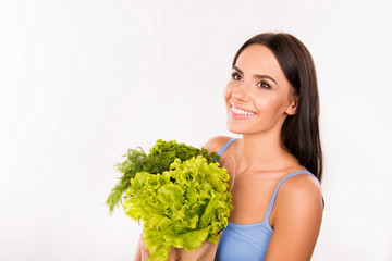 Cheerful smiling woman with a pack full of greens and vegetables