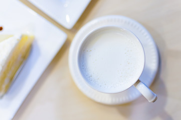 White cup of hot milk on a table